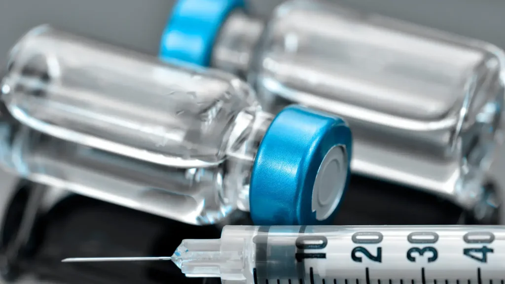 A close-up shot of two vials and a syringe.