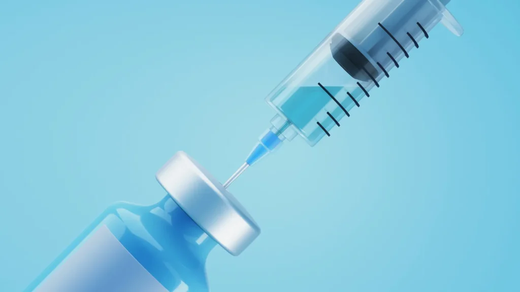 A close-up shot of a medical syringe transferring the solution into the injection.