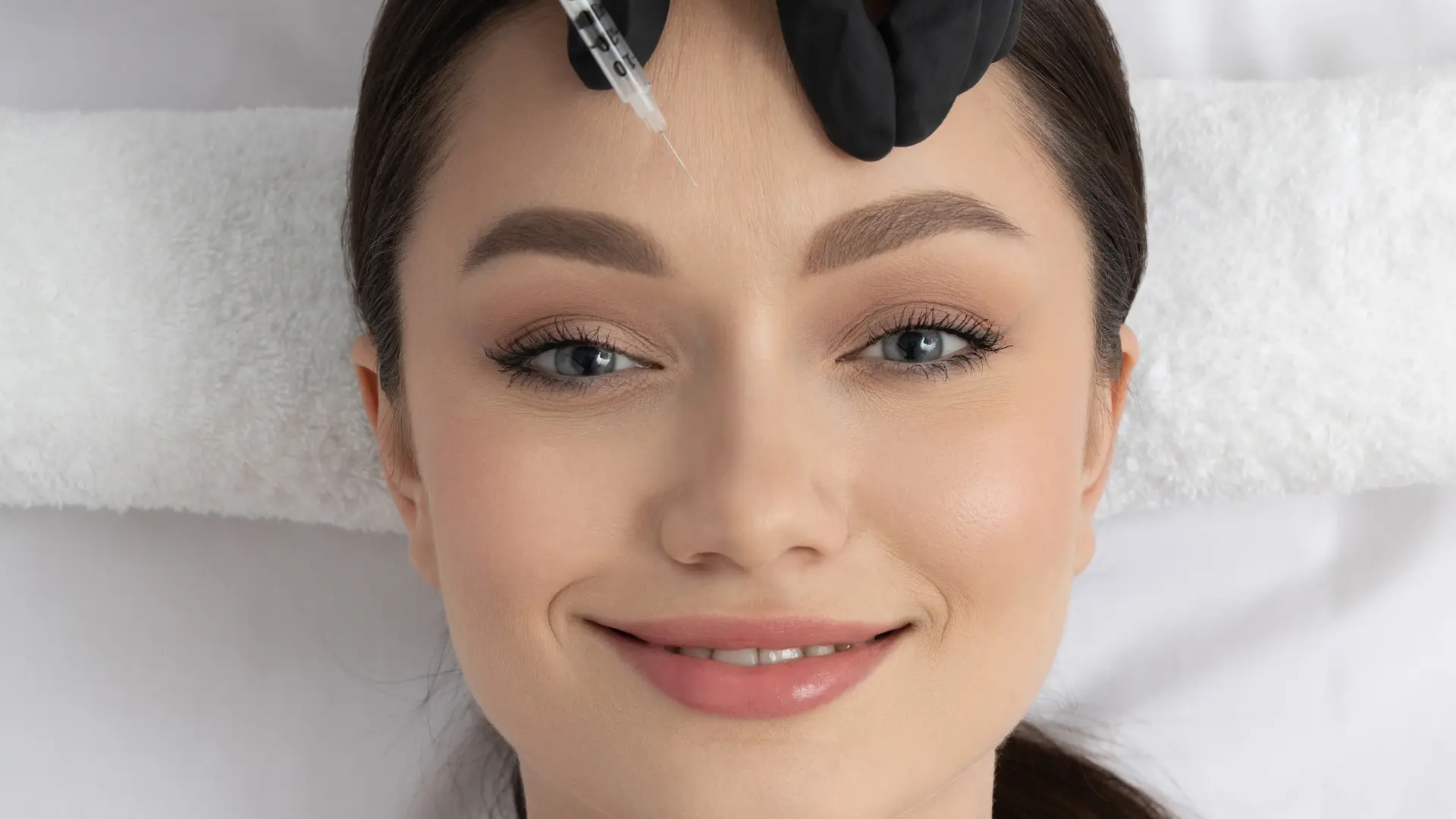 An individual receiving an injection into their forehead region.