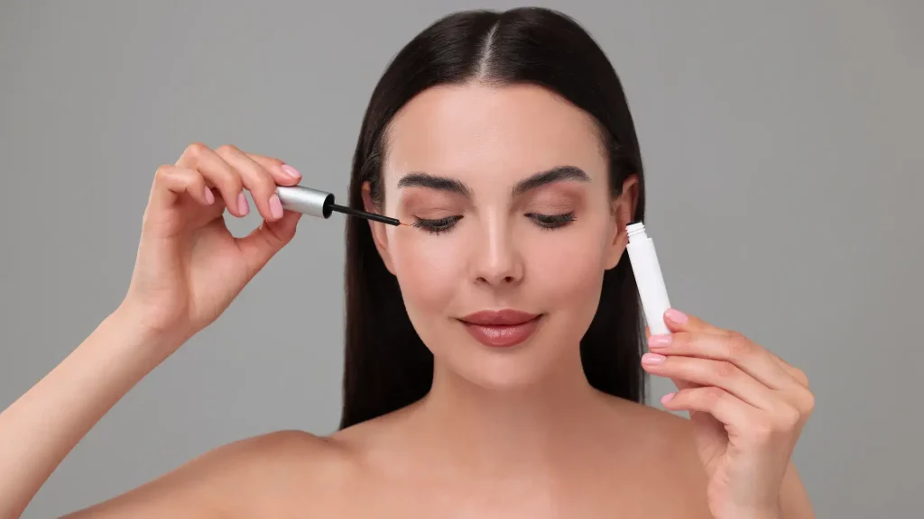 An individual in the process of applying a solution for eyelashes.