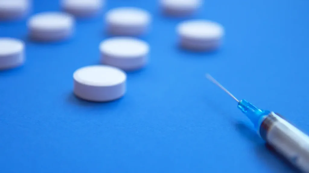 A close-up shot of an injection and tablets.