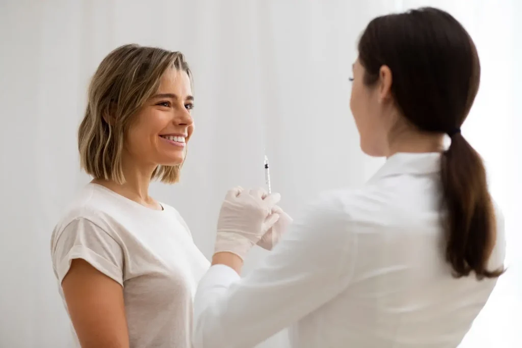 A medical professional preparing for injection into a patient's face.