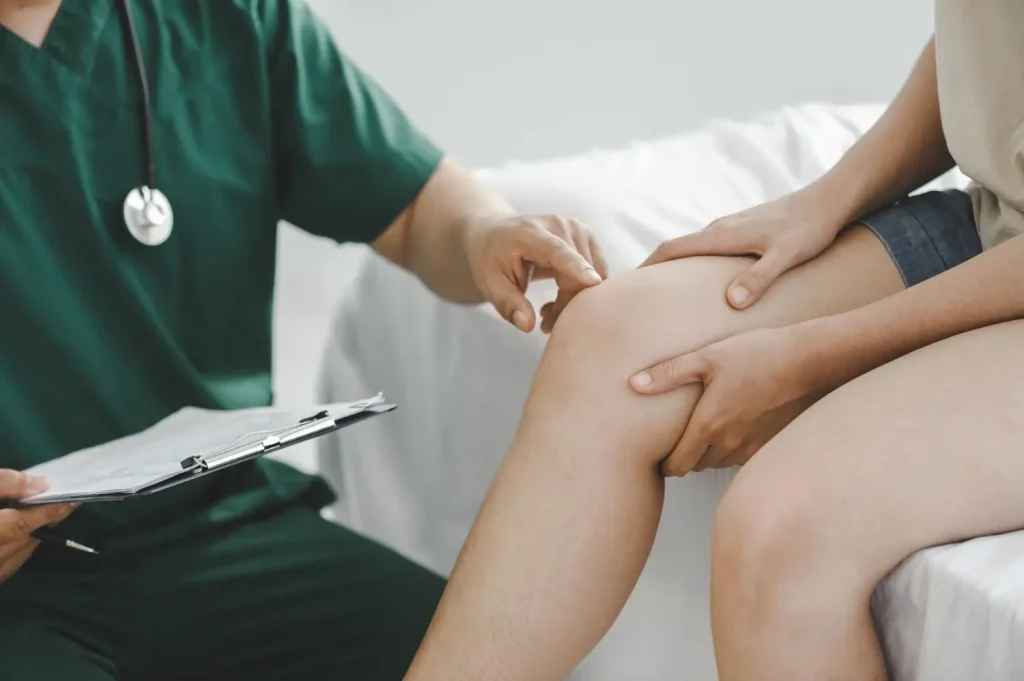 A medical professional examining a patient's knee.