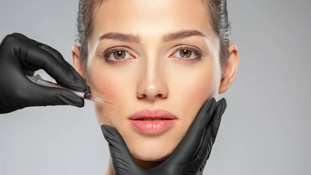 An individual receiving injection into their mid-face region.