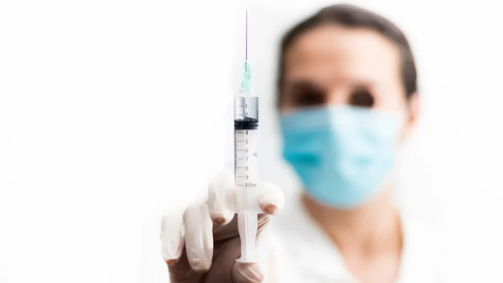 A healthcare professional holding an injection.