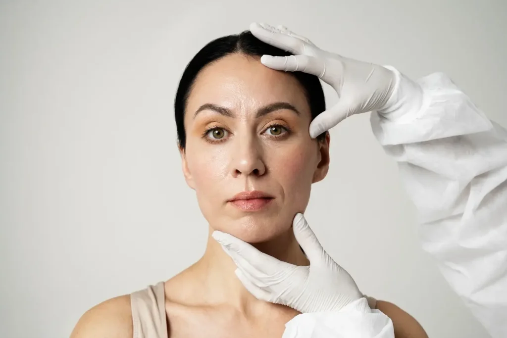 A medical professional examining a patient's face.