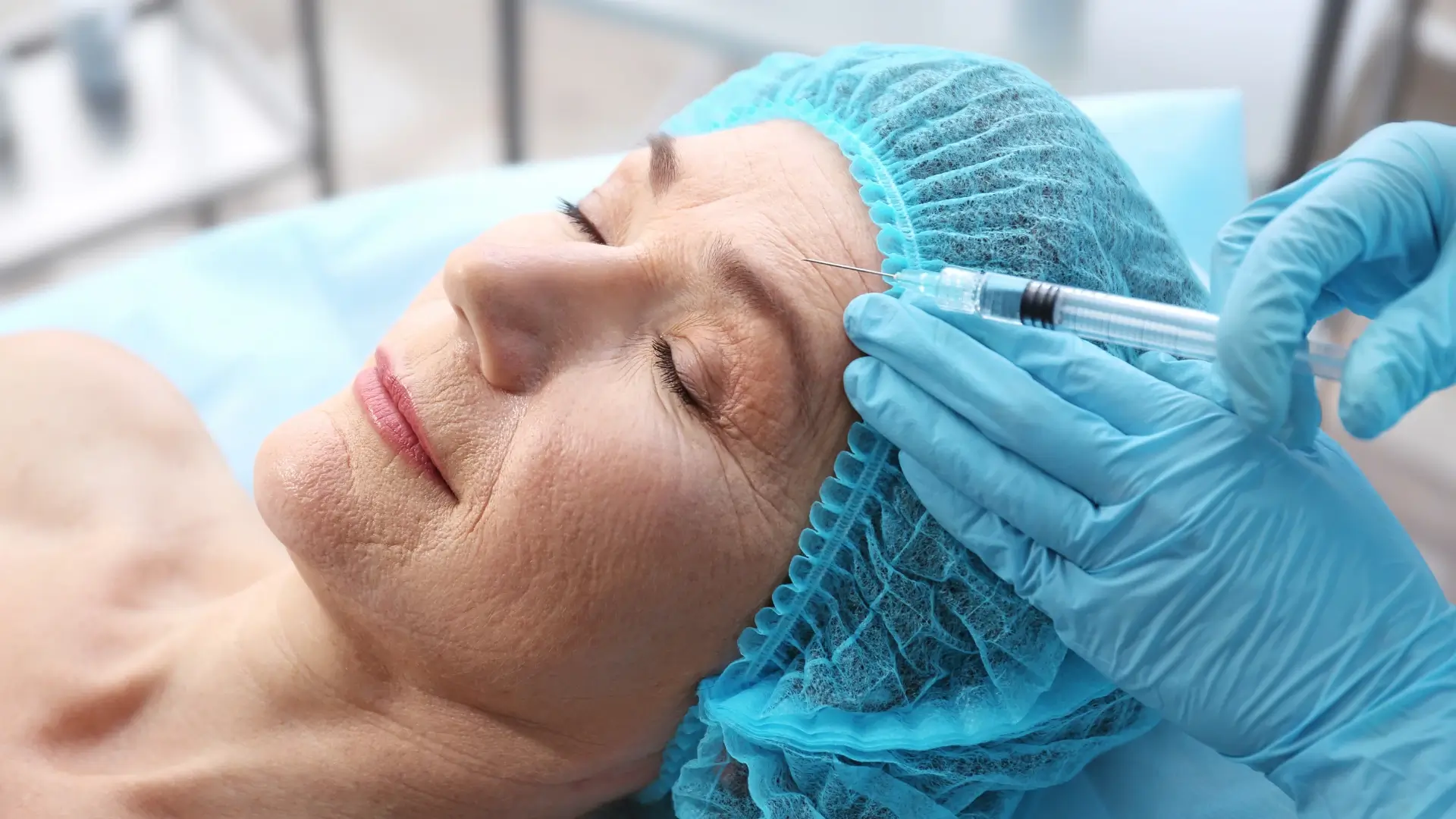 An older individual receiving facial injection into their forehead.
