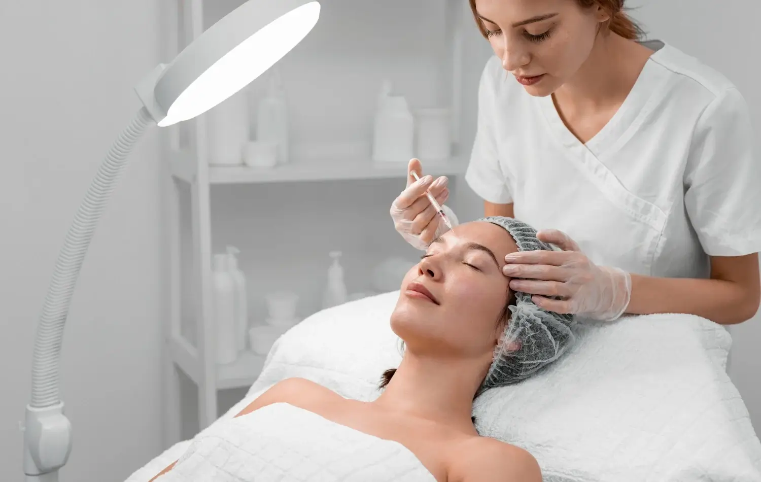 A medical professional administering a facial injection.