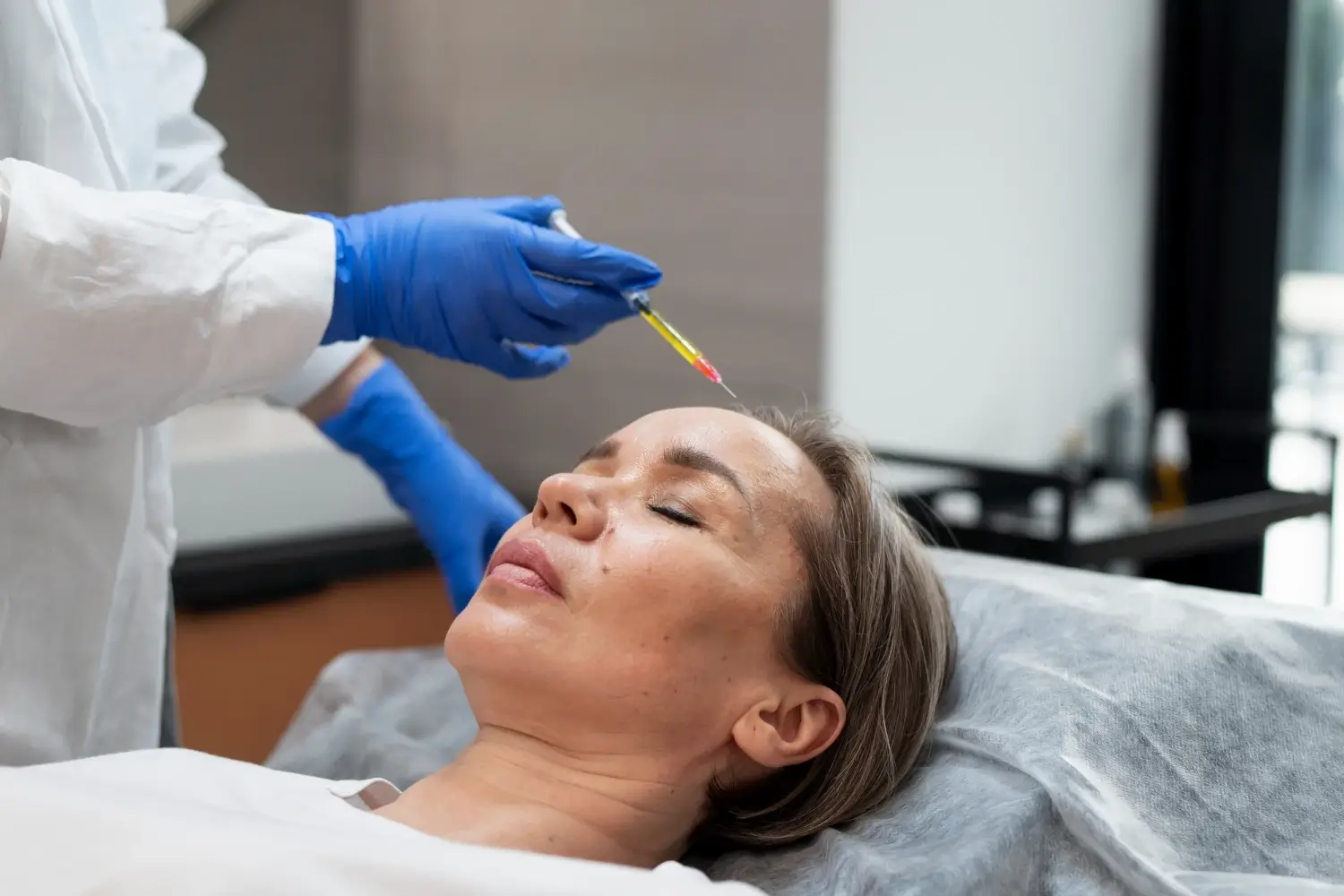 An individual undergoing a facial injection into their forehead.