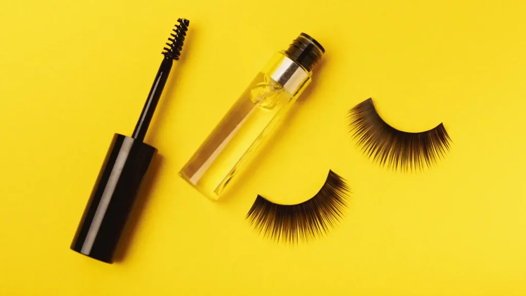 A photo of eyelashes with an applicator brush and serum.