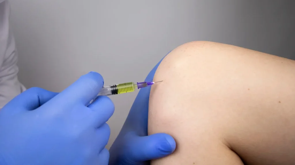 A medical professional administering a knee injection.