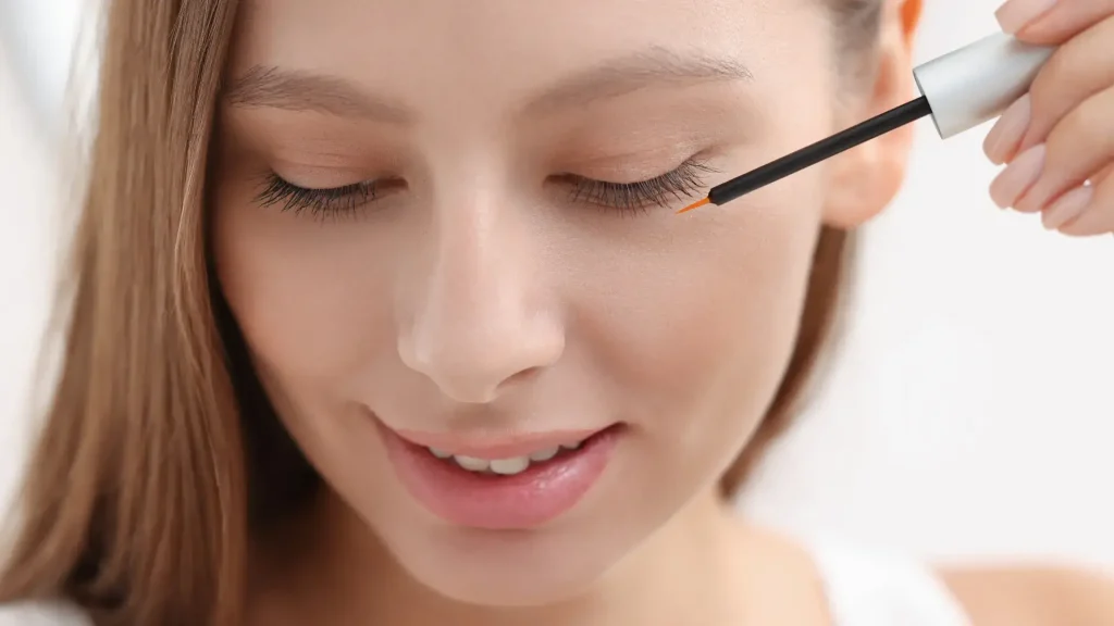 An individual applying a solution for their eyelashes.