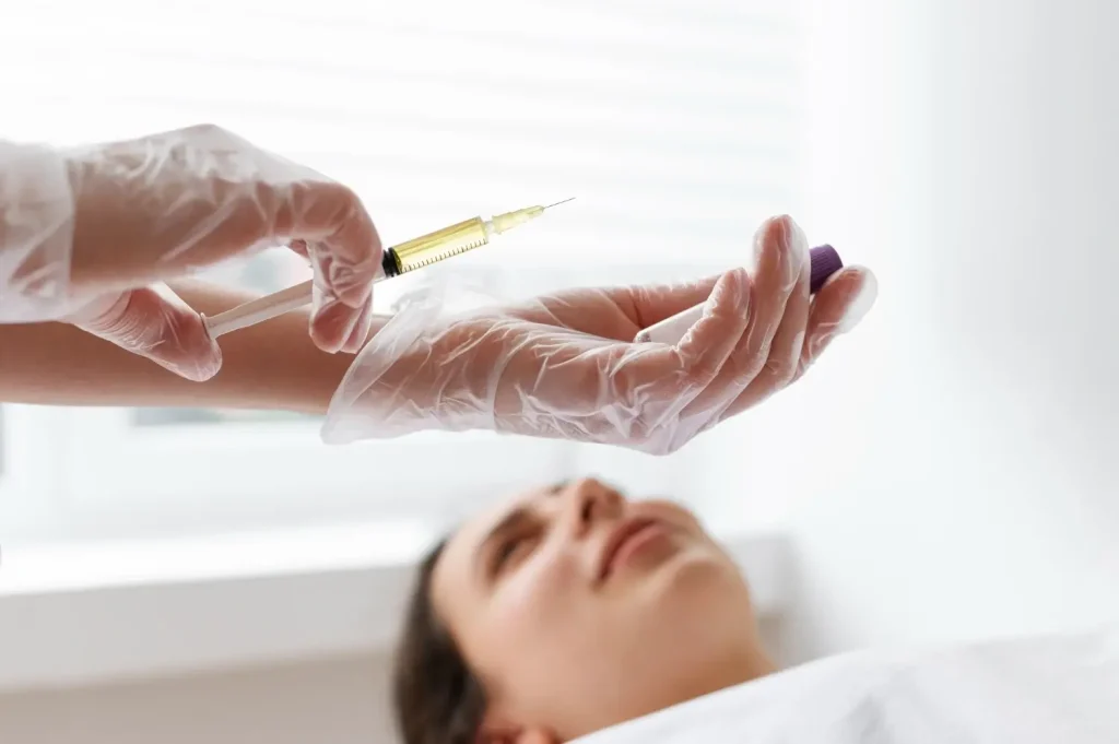 A medical provider holding an injection for the patient's facial treatment.
