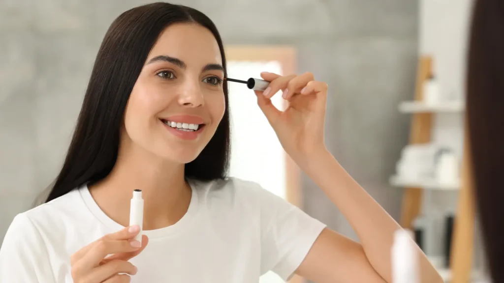 An individual applying a solution to their eyelashes.