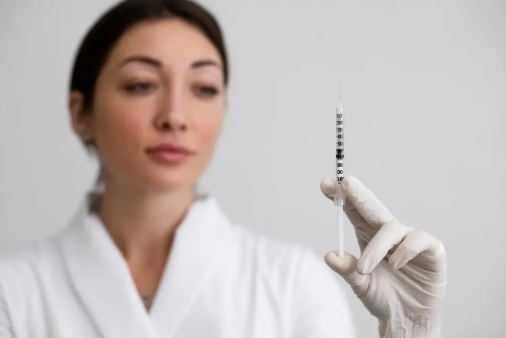 A medical provider holding a syringe.