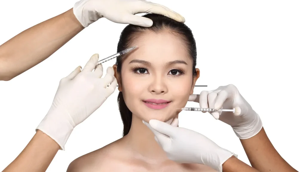 Two aesthetic providers administering facial injection into the patient.