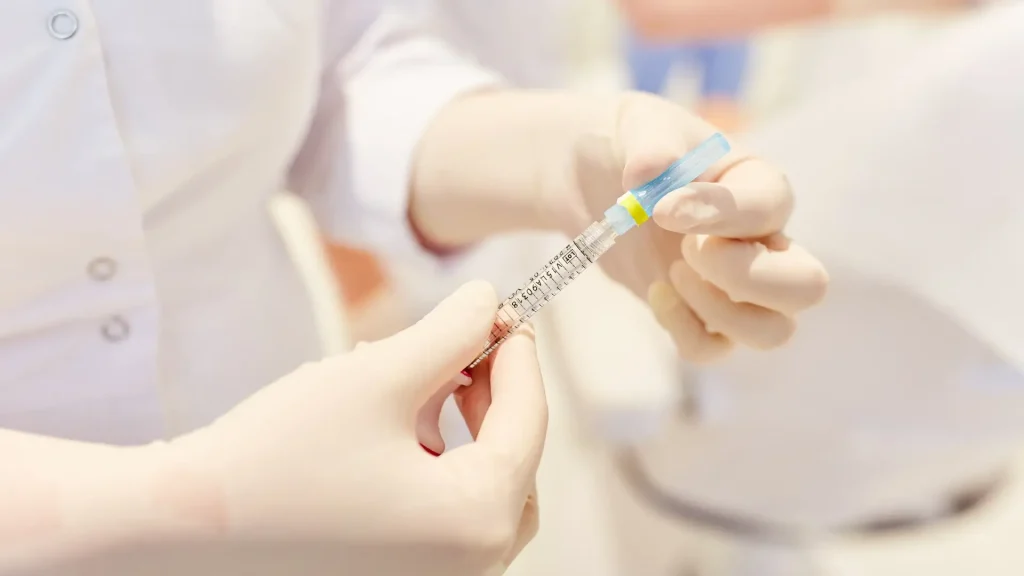 A medical practitioner preparing the injection for treatment.