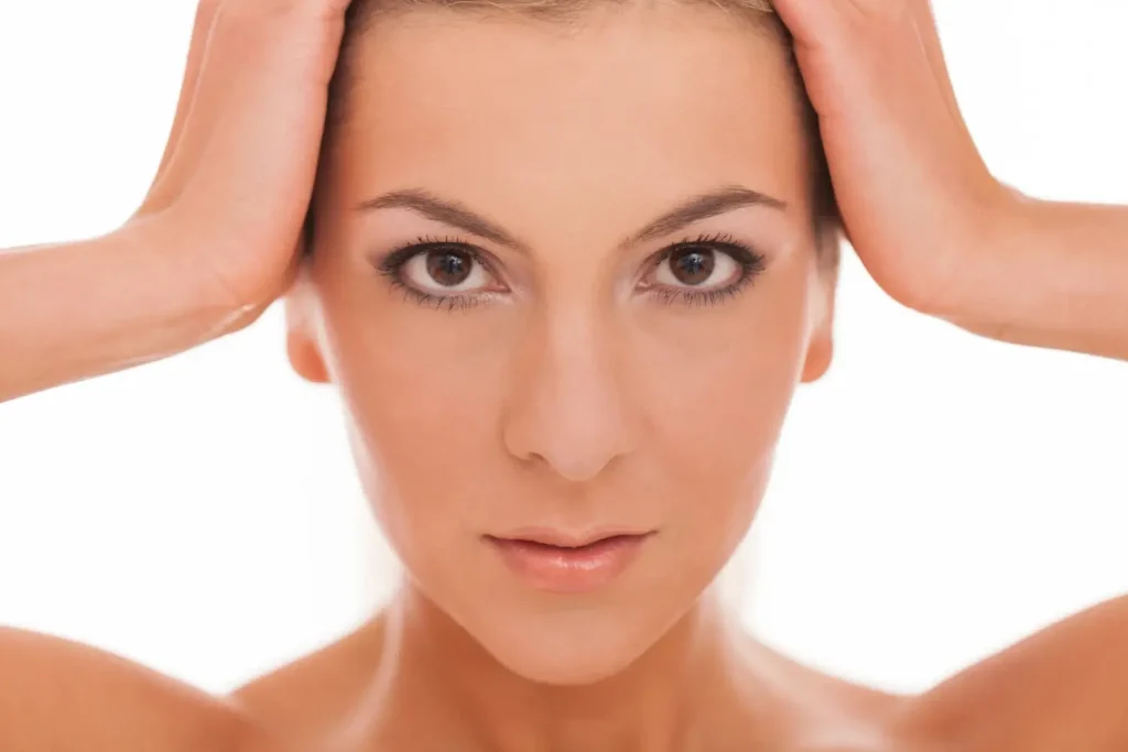 A woman showing off their youthful appearance, specifically in the under-eye region.