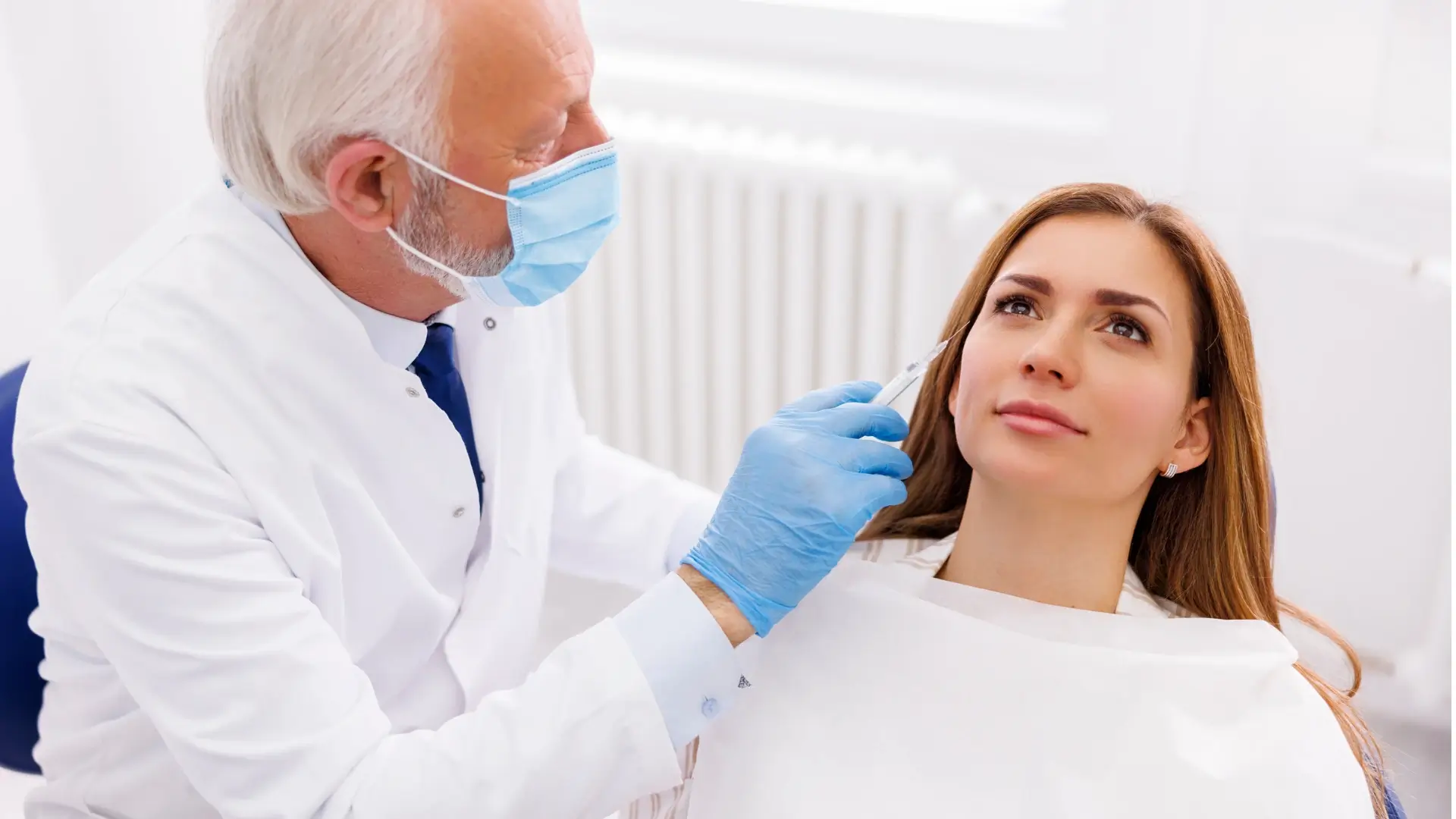 An aesthetic provider administering a facial injection into a patient.