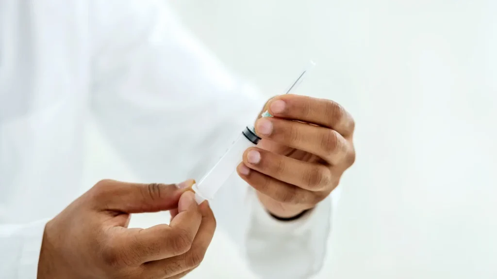 A medical professional holding an injection for treatment.