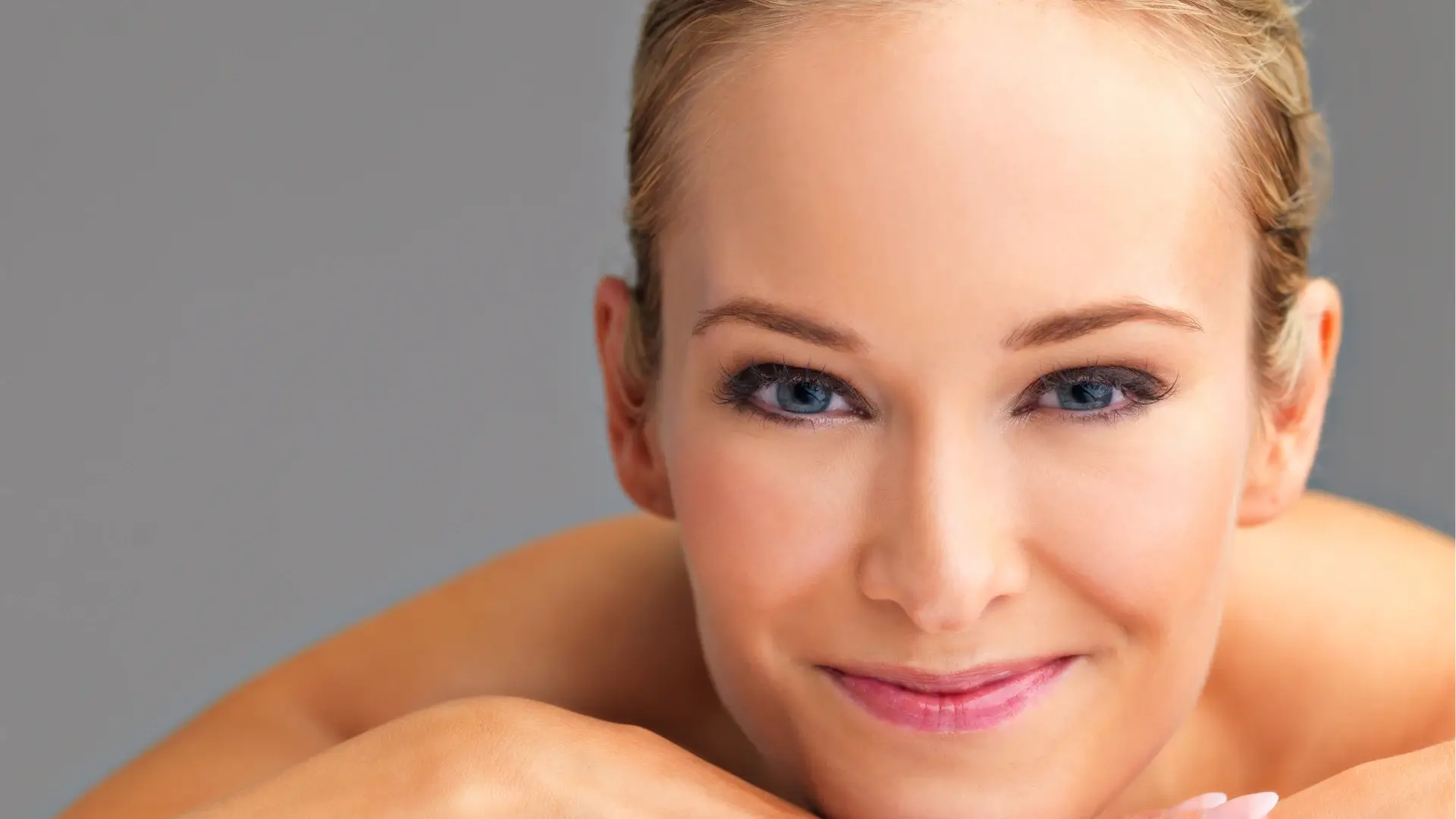 An individual smiling and showing off their smooth and clear facial skin.