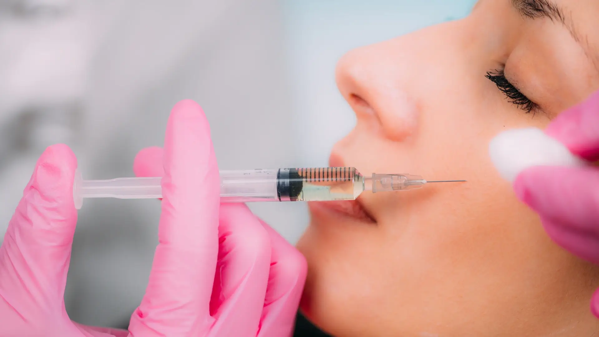 An individual receiving a cheek injection from a medical professional.