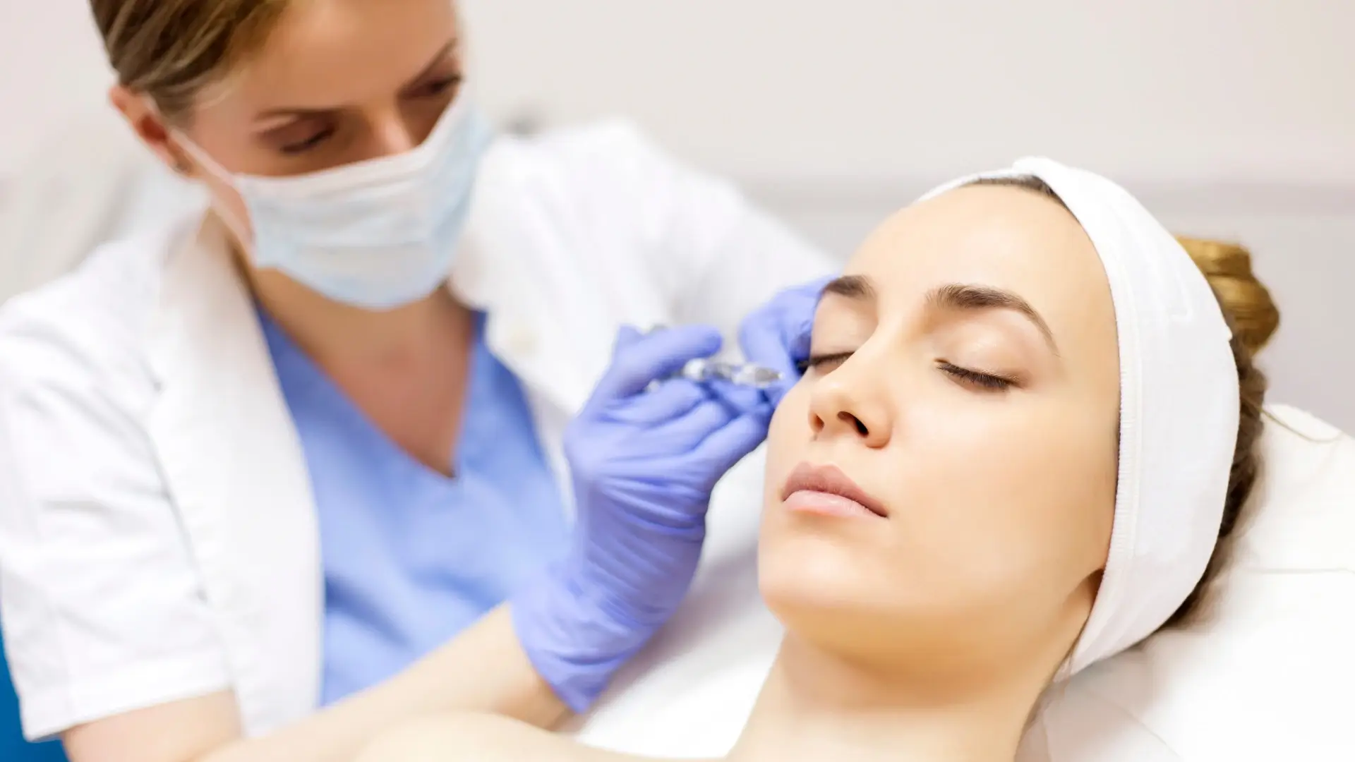 A medical professional administering a facial injection.