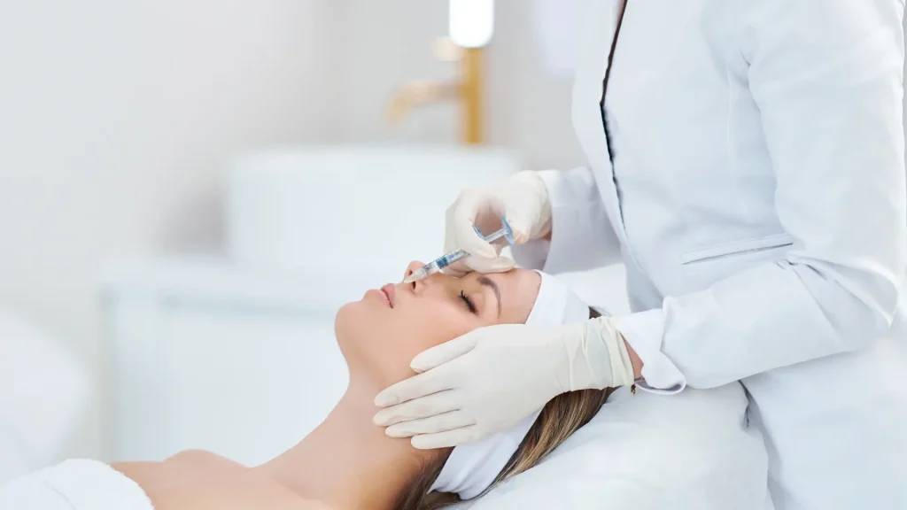 A medical professional administering an injection into a patient's lip region.