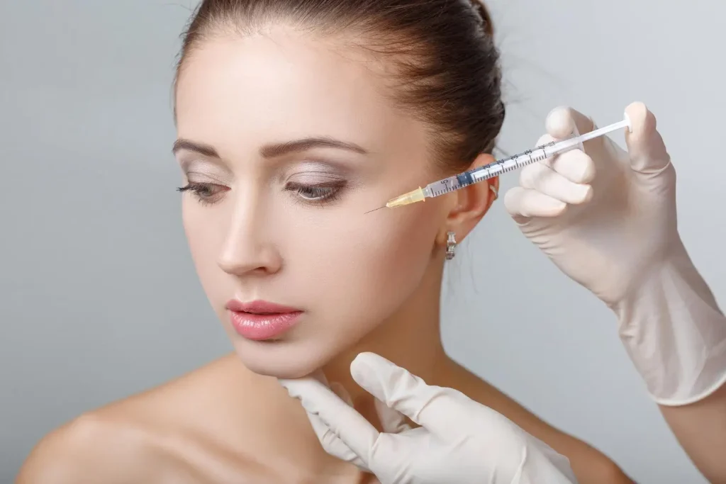 An individual undergoing a cheek injection for their facial enhancement.