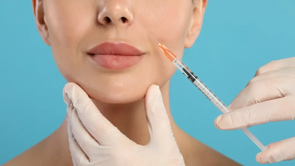 A medical practitioner administering an injection into a patient's nasolabial folds.