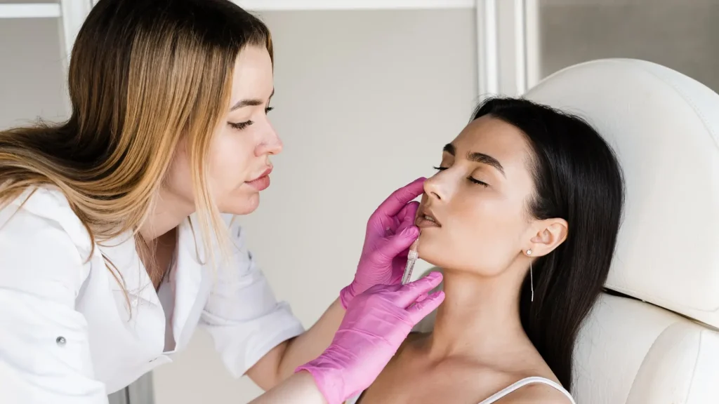 An injection procedure with an aesthetic professional administering an injection into the patient's lower face.