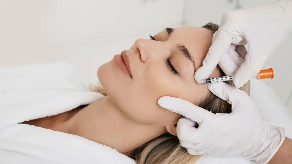 A medical professional administering a facial injection into a patient.