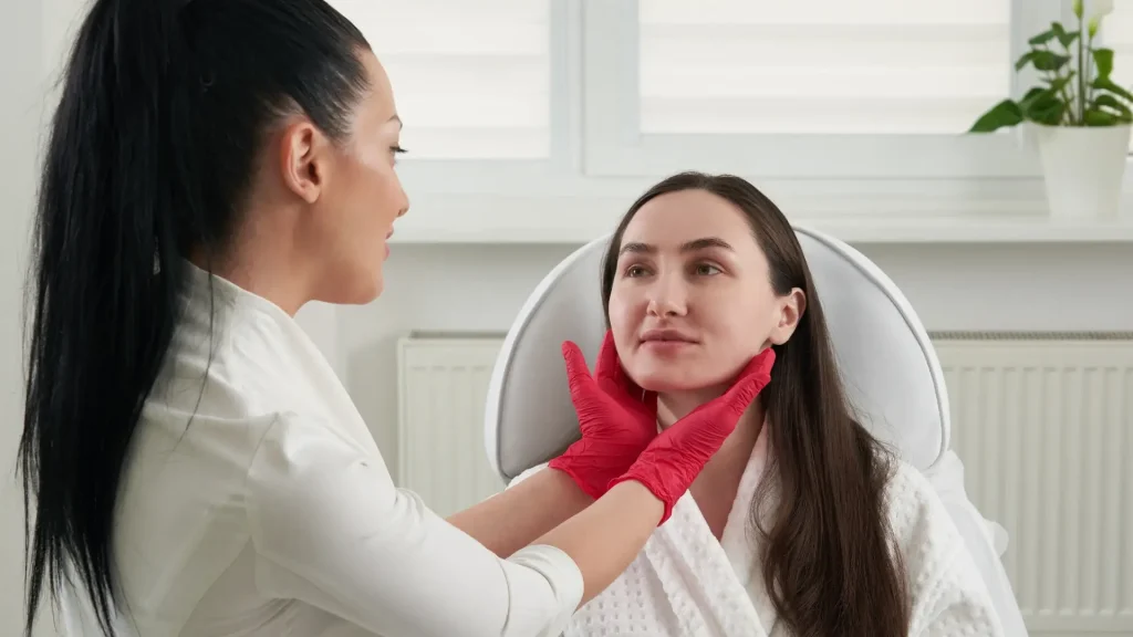 A skin expert assessing a patient's facial skin.
