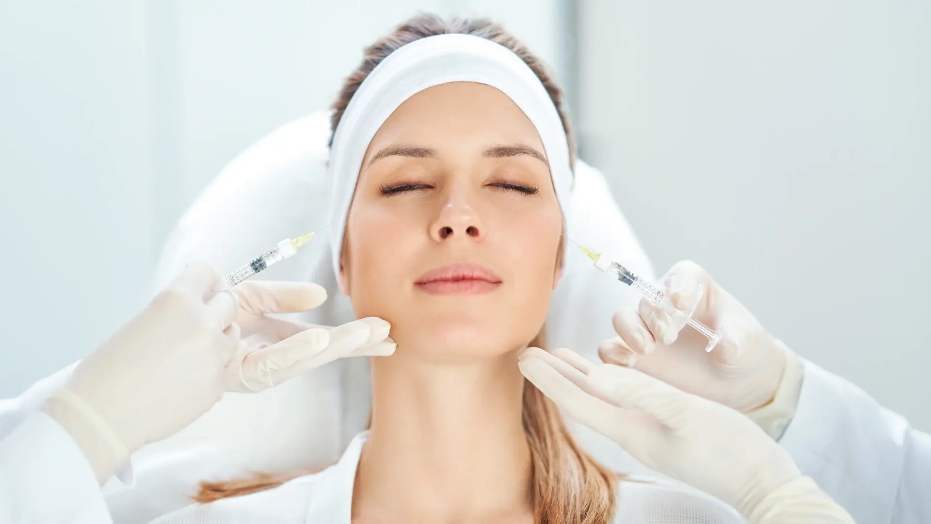 An individual receiving two injections in their facial region.