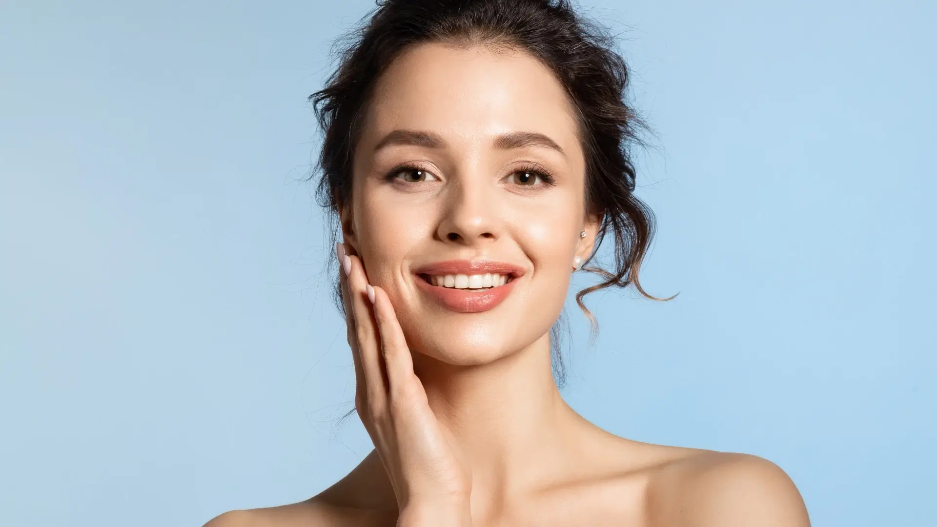 An individual showing their smooth and glowing facial skin.