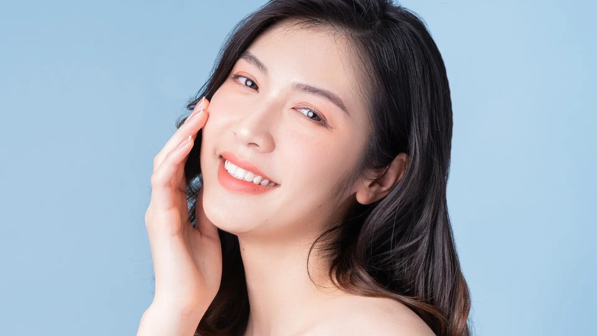 A happy woman showing of their clear and smooth facial skin.