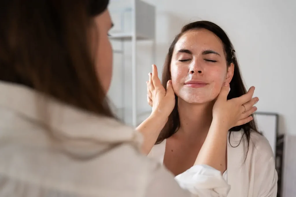 An aesthetic provider assessing a patient's facial skin.