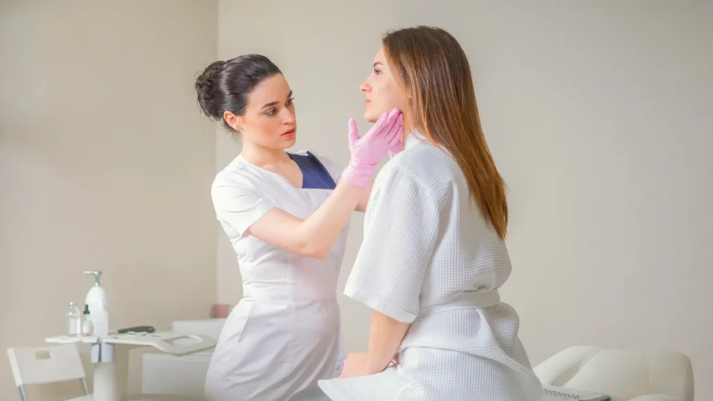 A beautician examining the patient's facial region.