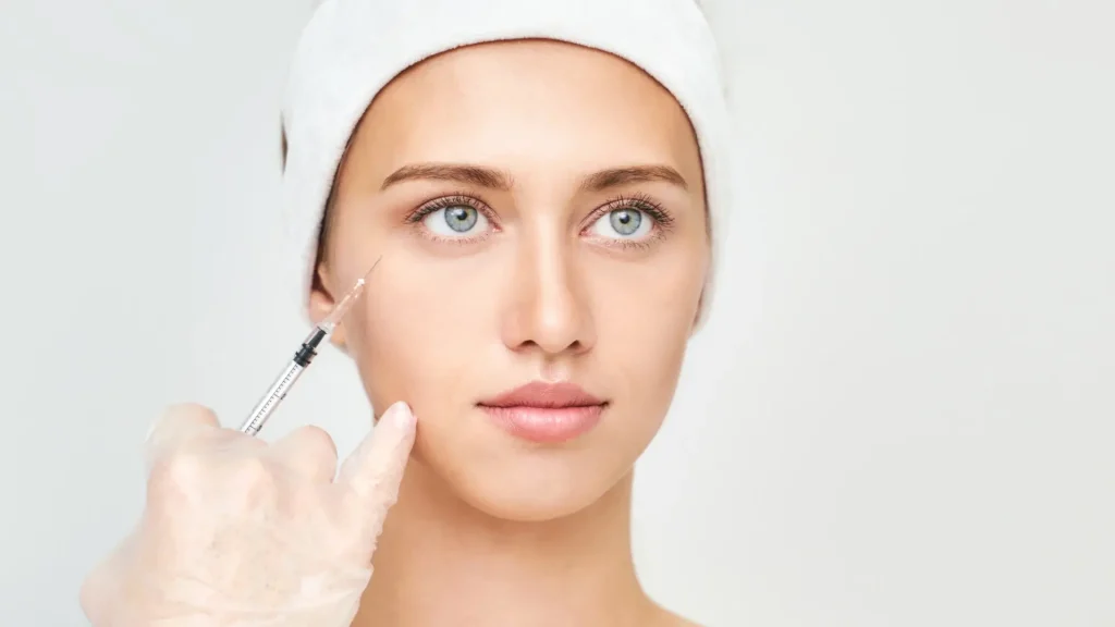 An aesthetic professional administering an injection for the patient's tear troughs.