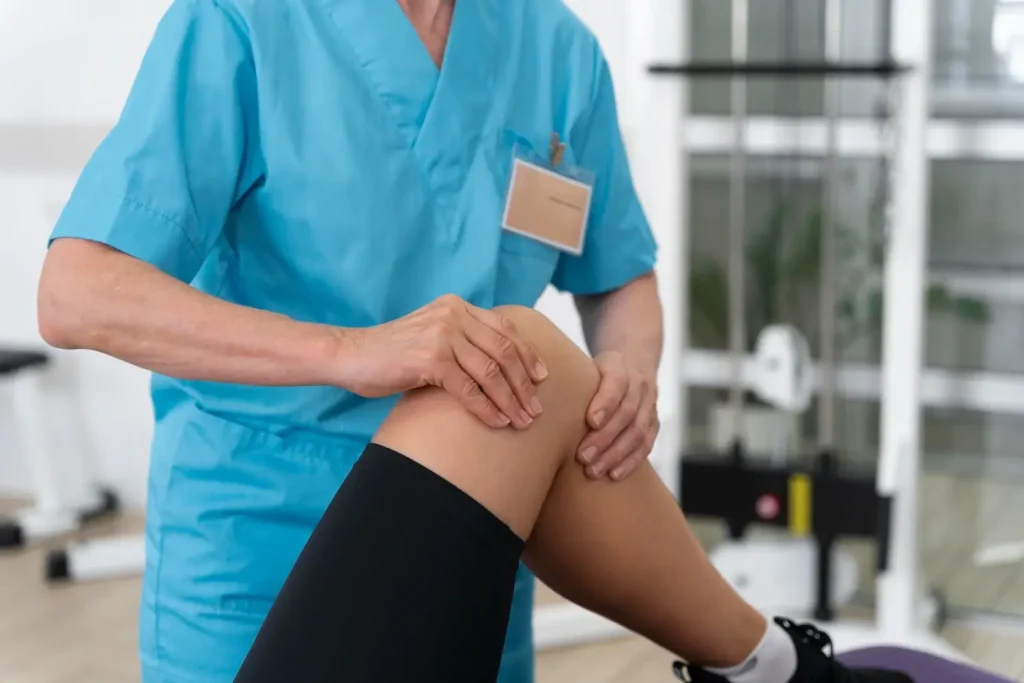 A healthcare provider examining a patient's knee joint.