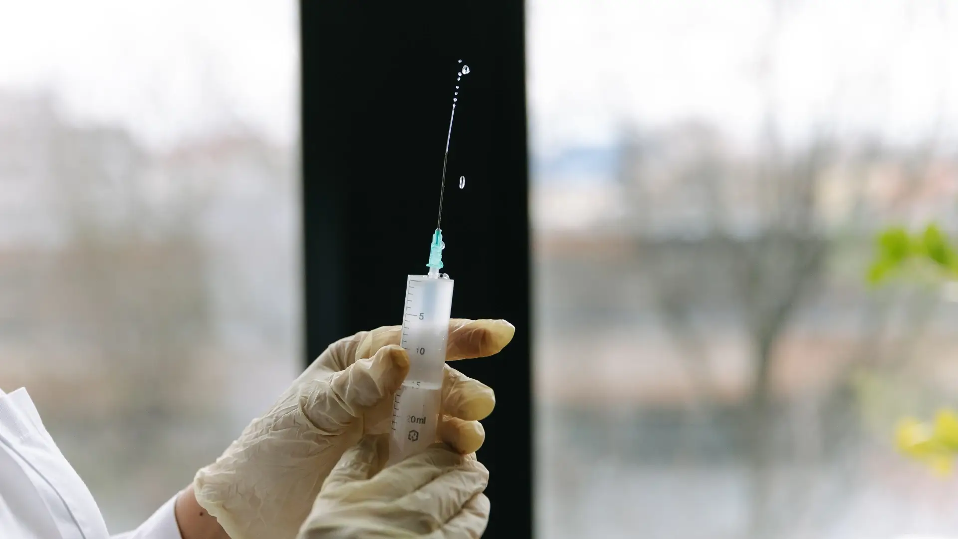 A medical professional holding an injection.