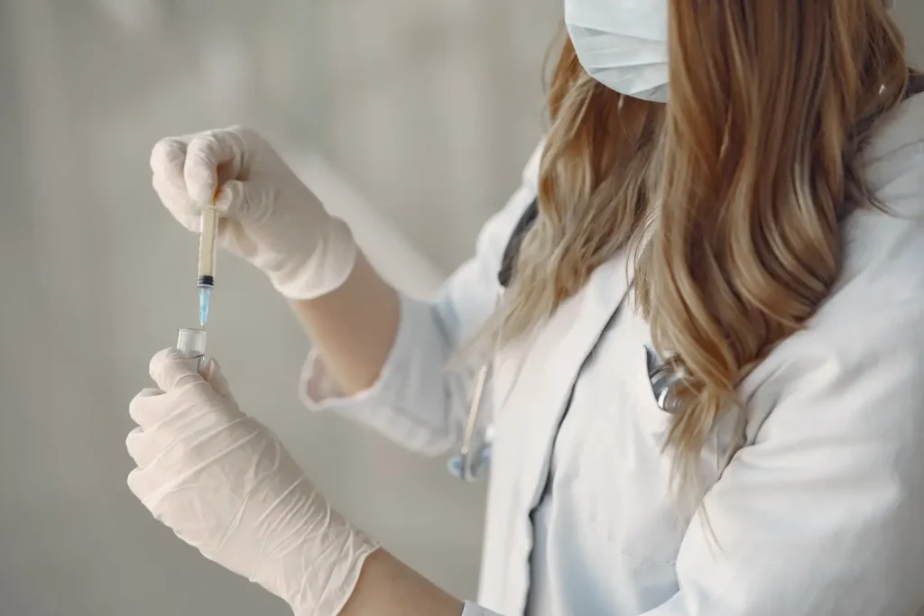 A medical professional transferring the solution into a syringe.