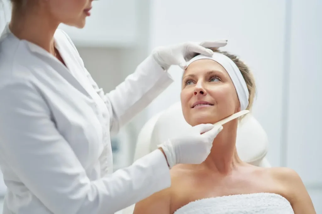 An individual undergoing a facial examination with an aesthetic provider.