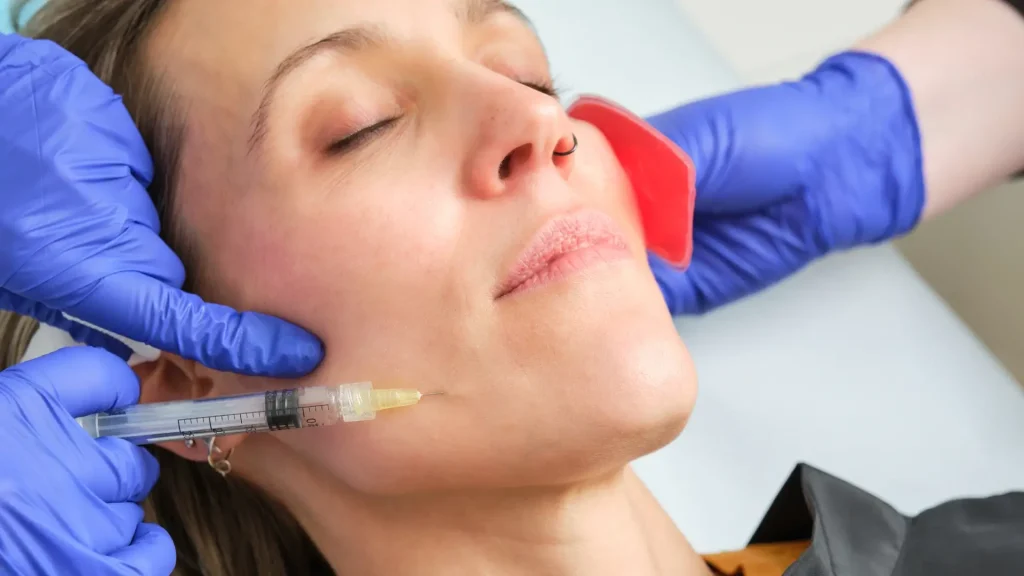 An individual receiving a facial injection from a medical professional.