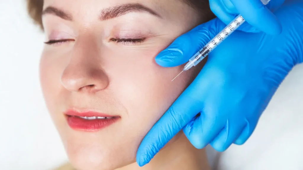 An individual receiving cheek injection from a medical professional.