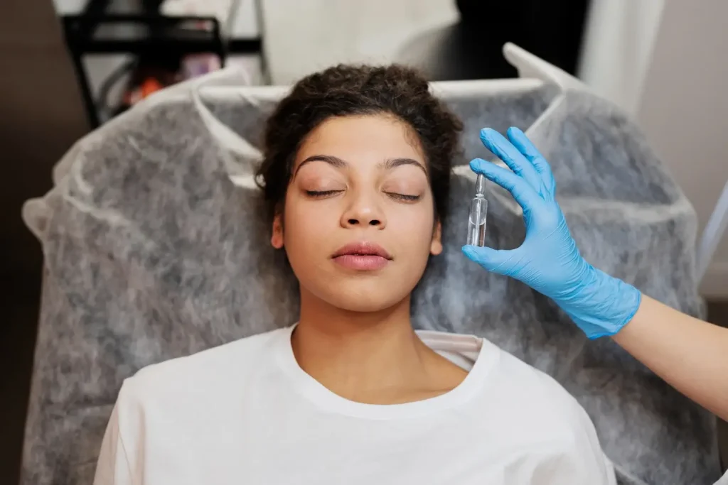 A medical practitioner showing the solution vial beside the patient's face.