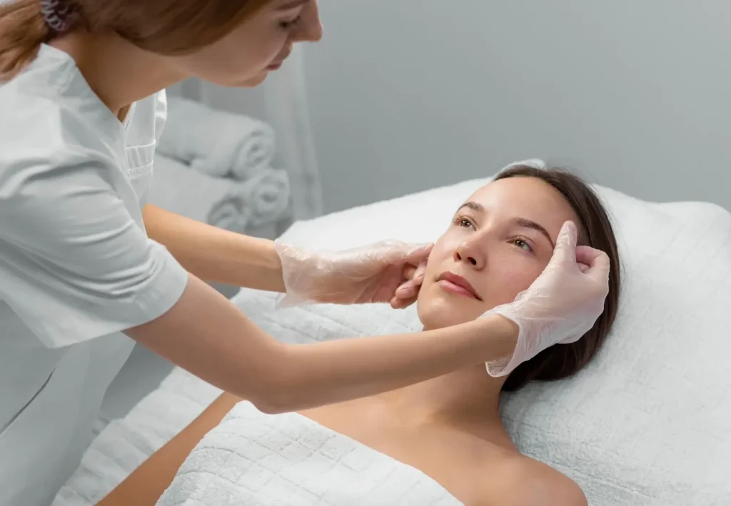 An aesthetic provider assessing a patient's facial skin.
