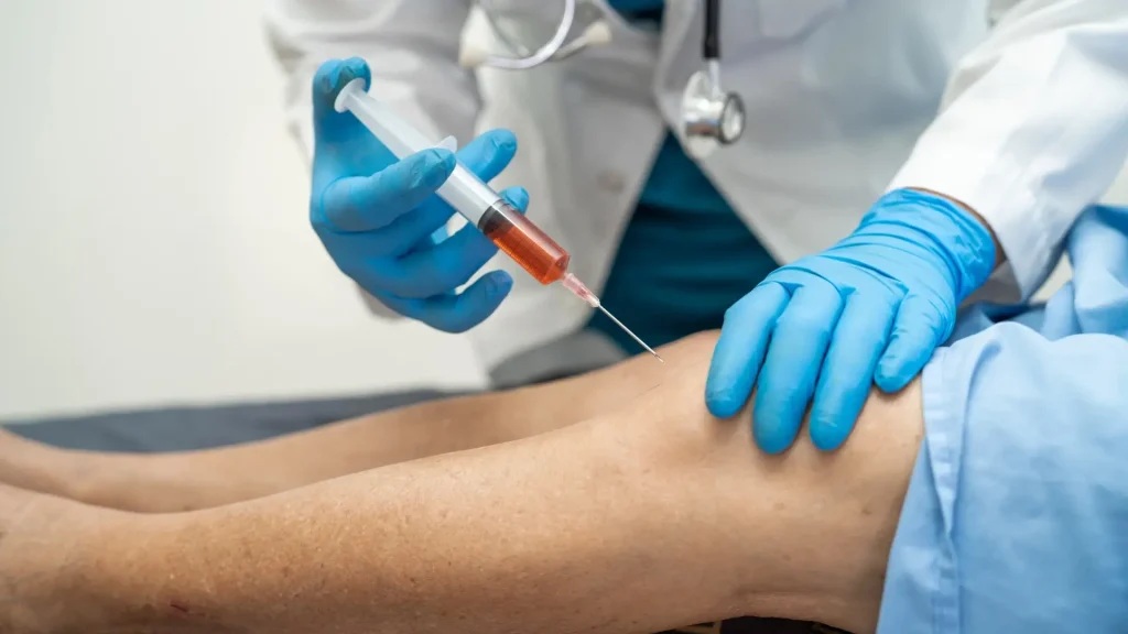 A healthcare provider administering a knee injection.