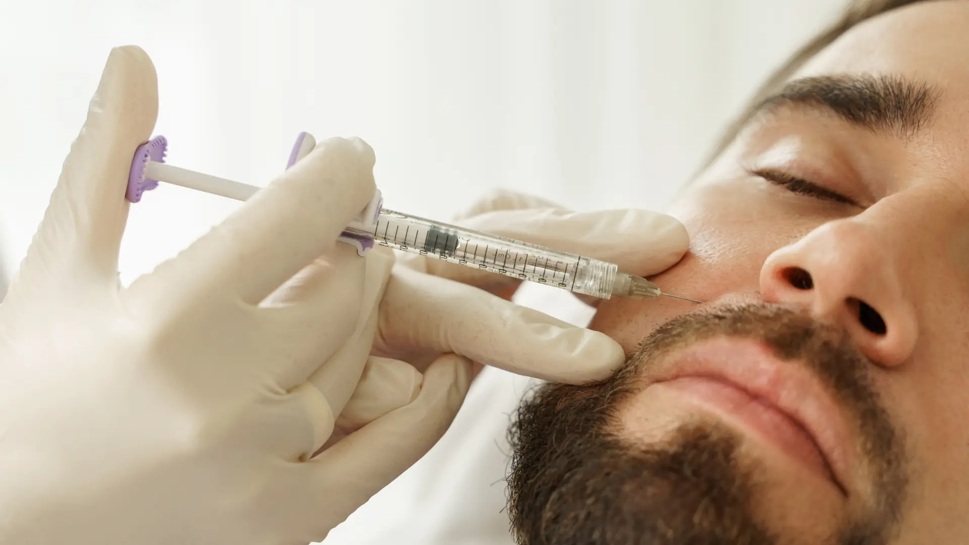 A male individual receiving an injection for their midface region.