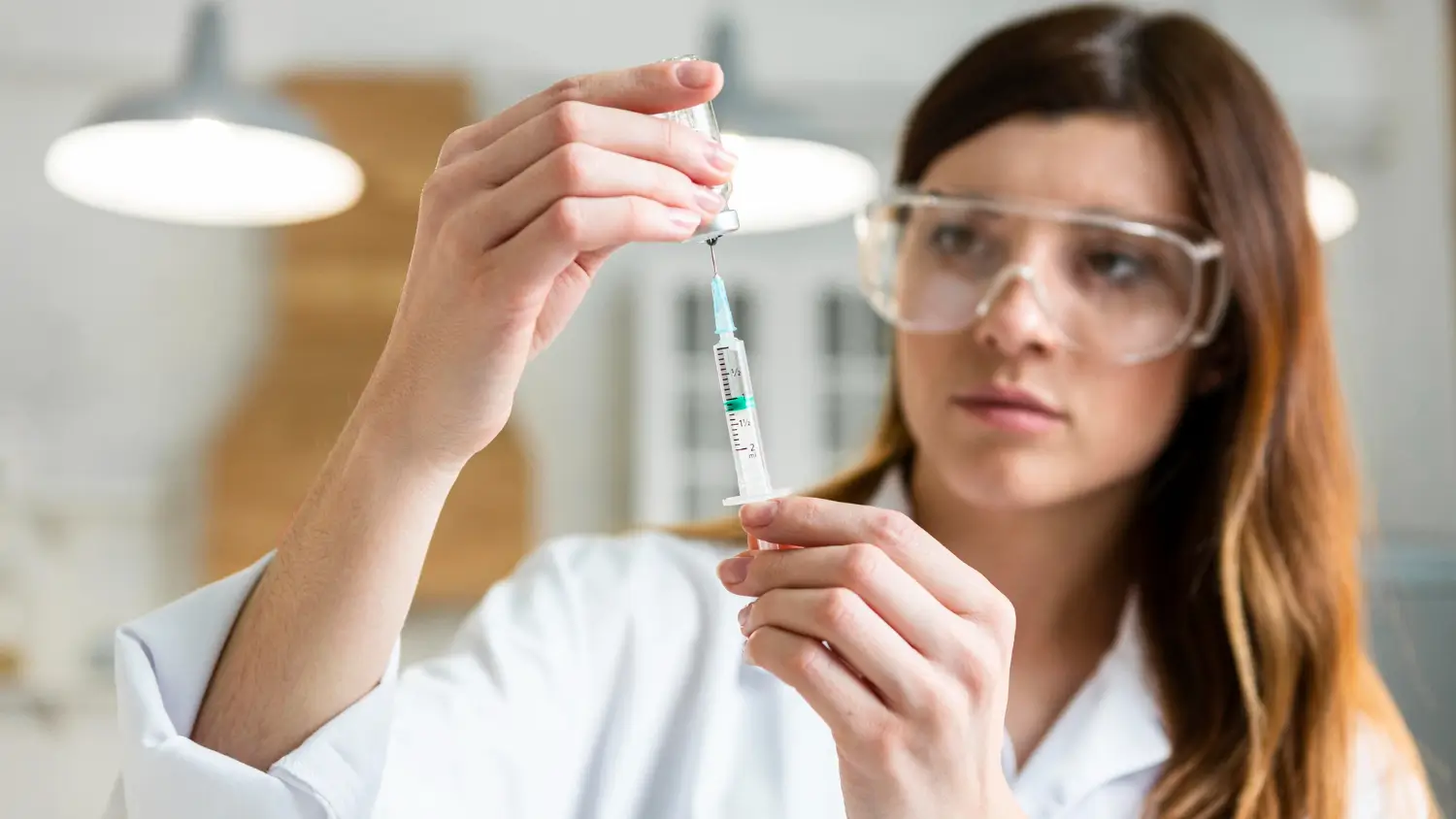 A medical provider transferring the vial's content into the syringe.